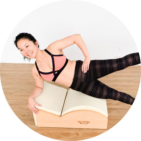 An image of a pilates spine corrector: a small barrel with an angled portion. Used to work on abs and spinal mobility.